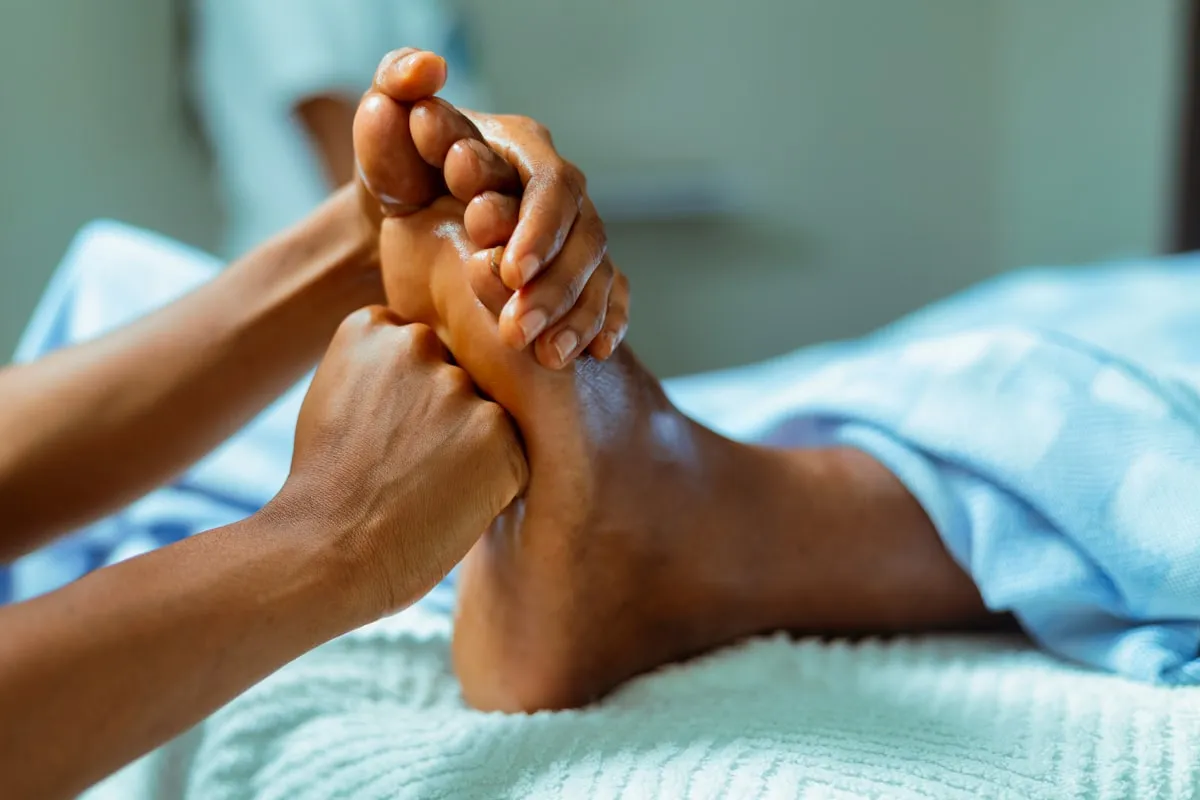 Séance de réflexologie plantaire, mains travaillant la voûte du pied